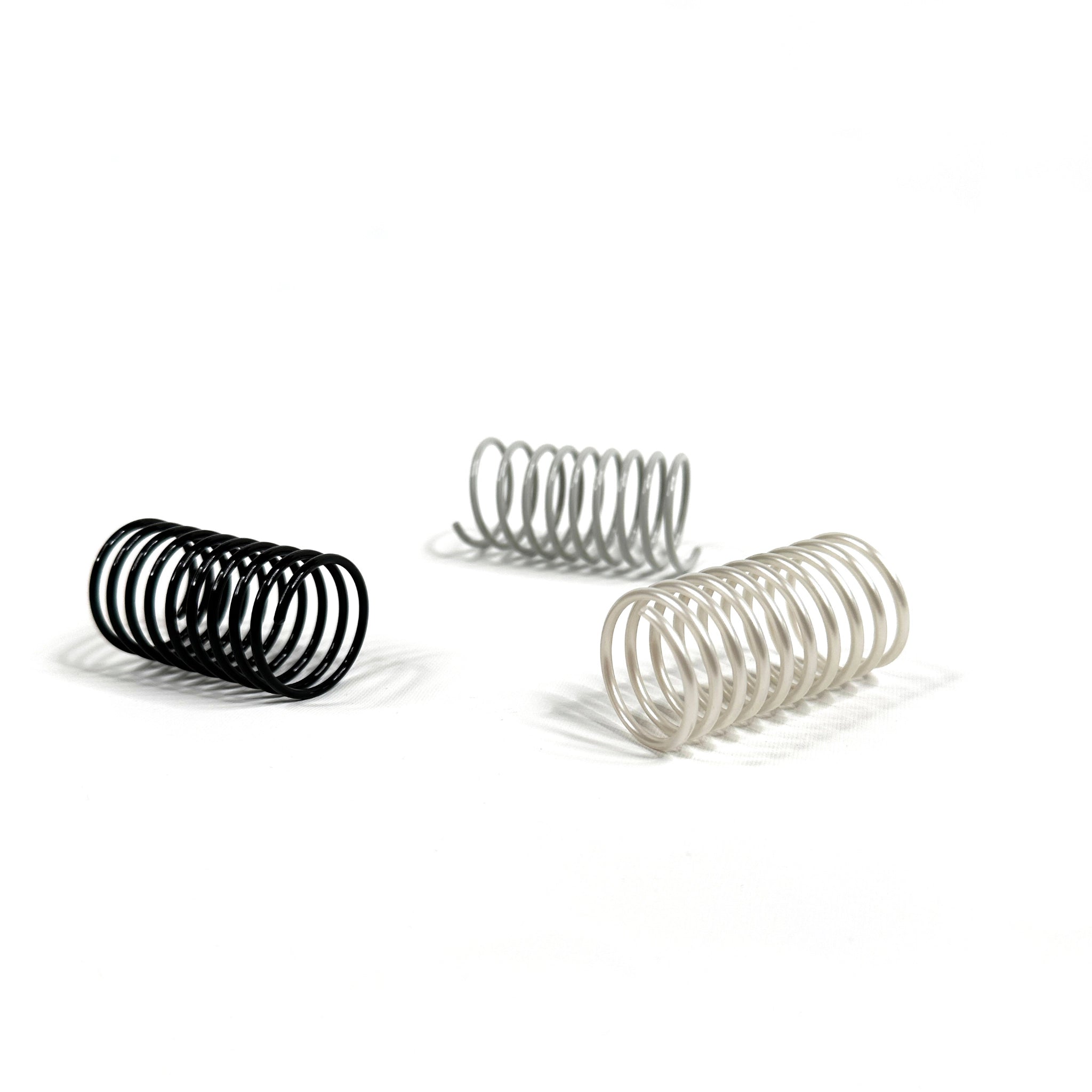 Drei Katzenspiralen in Grau und Schwarz – langlebiges, geräuscharmes Katzenspielzeug aus Frankreich im minimalistischen Design.