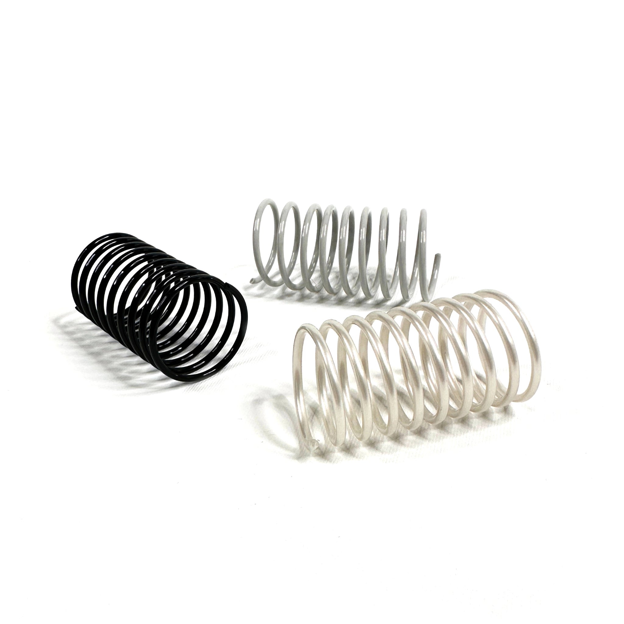 Drei Katzenspiralen in Grau und Schwarz – langlebiges, geräuscharmes Katzenspielzeug aus Frankreich im minimalistischen Design.