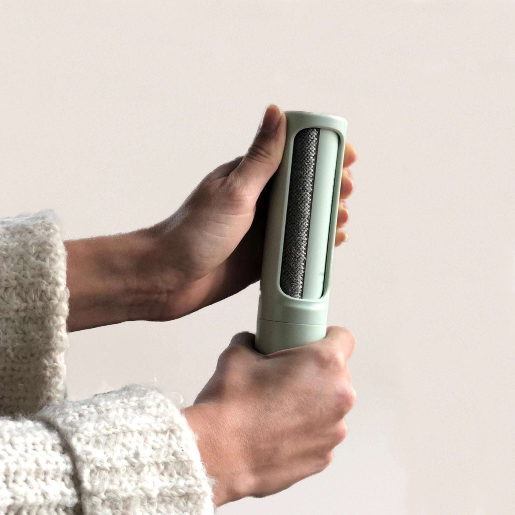 Fusselrolle für Tierhaare wird von zwei Händen bedient – nachhaltiger Tierhaarentferner für Kleidung und Möbel.